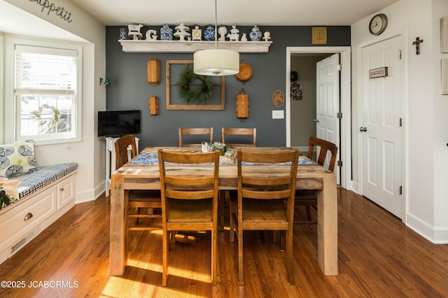 dining room with dark wood-type flooring and baseboards