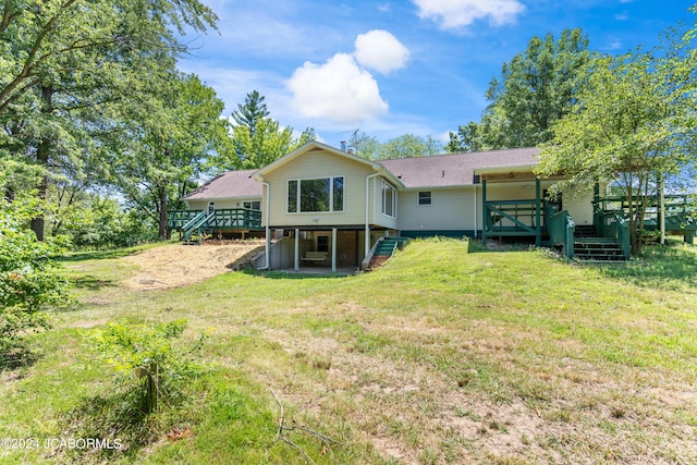 rear view of property featuring a lawn and a deck