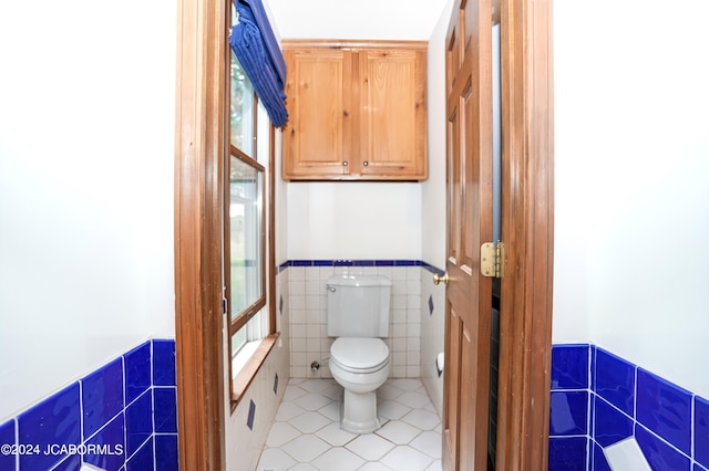 bathroom featuring tile patterned floors, tile walls, and toilet