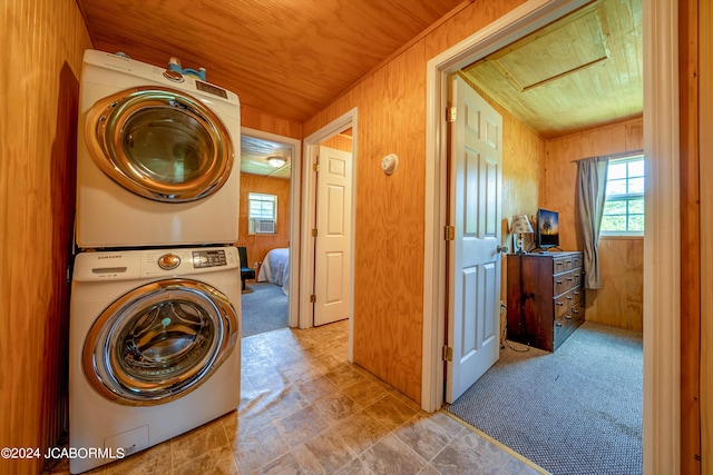 laundry area with wood walls, wooden ceiling, and stacked washer / drying machine