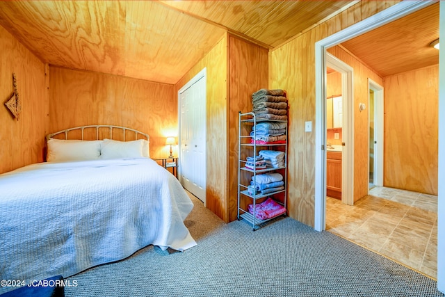 bedroom featuring a closet, wooden ceiling, and wood walls