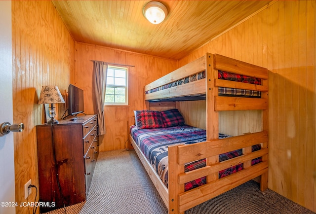 carpeted bedroom featuring wooden ceiling and wood walls