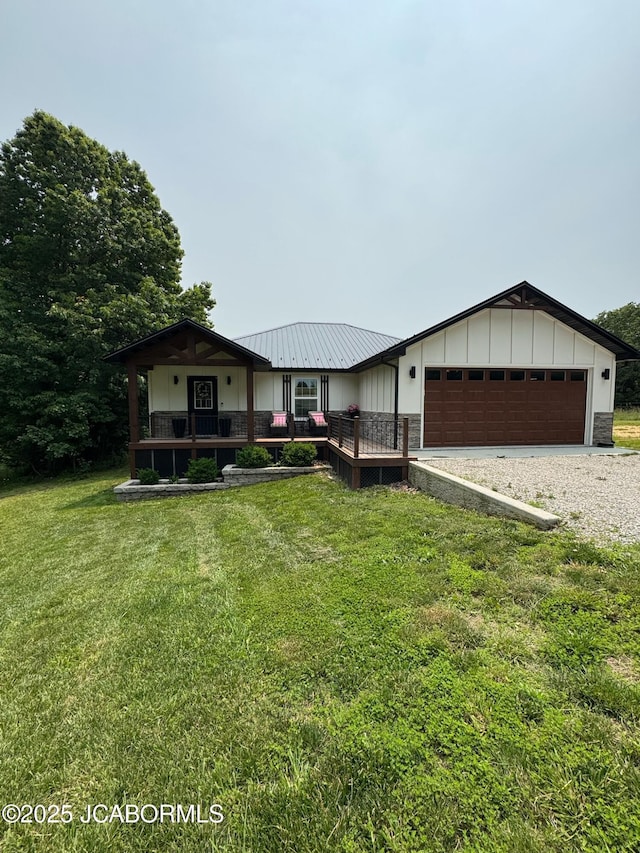 57421 Lake Imhoff Rd, California, MO 65018 - view of front of home with gravel driveway, a garage, a front yard, board and batten siding, and metal roof