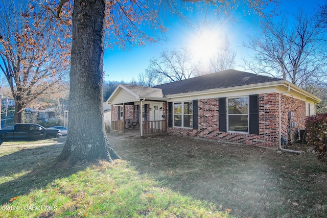 ranch-style home with a front yard and a porch