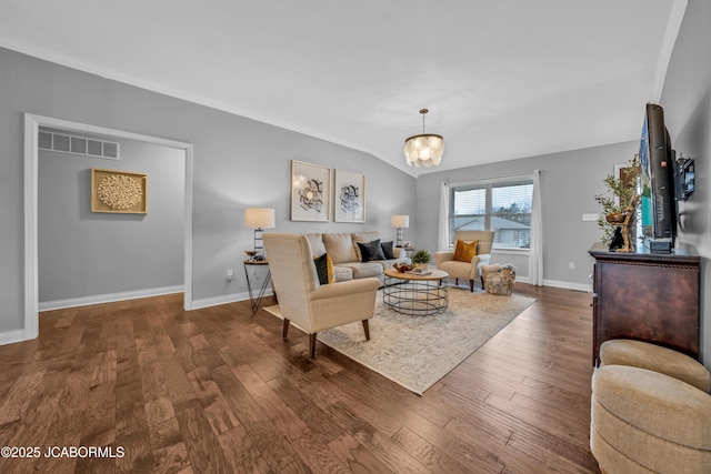 living room with dark hardwood / wood-style floors, a chandelier, and vaulted ceiling