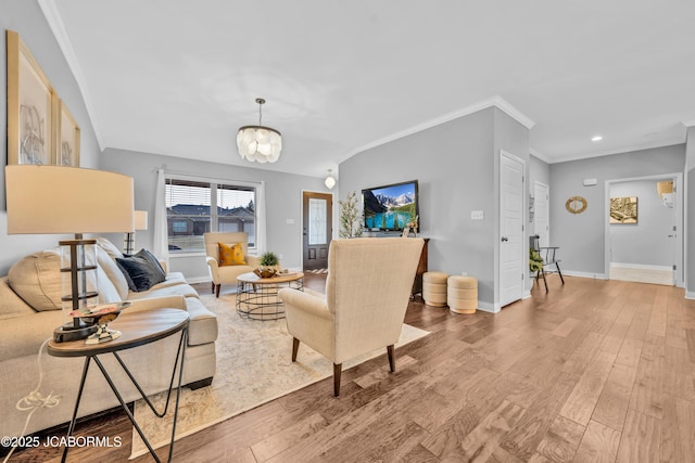 living room with ornamental molding, a chandelier, and hardwood / wood-style floors