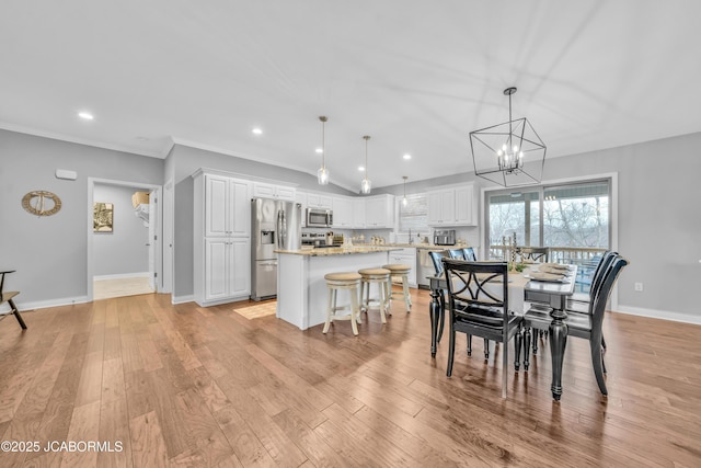 dining area featuring crown molding and light hardwood / wood-style flooring