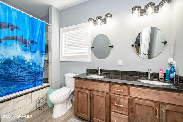 full bathroom with shower / tub combo, vanity, wood-type flooring, and toilet