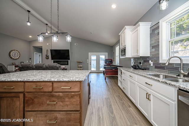 kitchen with stainless steel appliances, sink, a kitchen island, and white cabinets