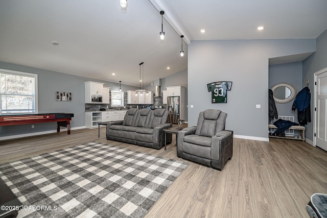 living room featuring light hardwood / wood-style flooring and high vaulted ceiling