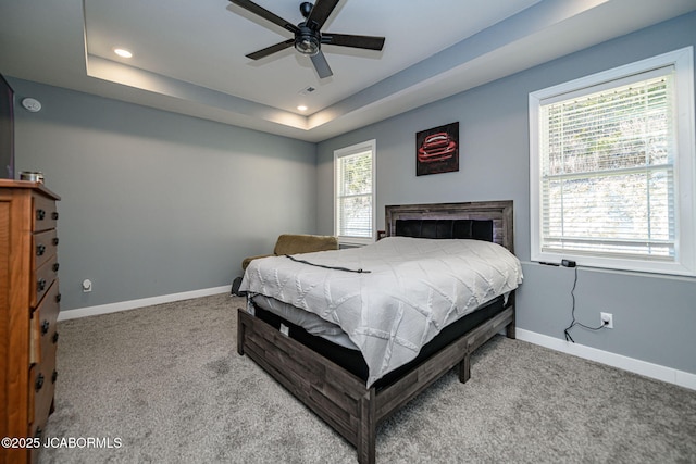 bedroom featuring light carpet and a tray ceiling