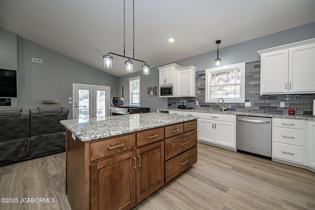 kitchen featuring white cabinetry, stainless steel appliances, a kitchen island, and hanging light fixtures