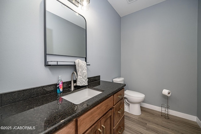 bathroom featuring vanity, wood-type flooring, and toilet