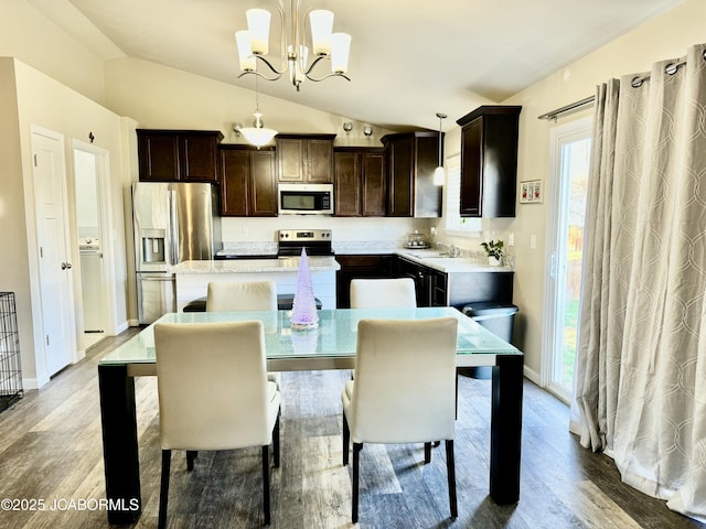 kitchen featuring stainless steel appliances, light countertops, an inviting chandelier, a kitchen island, and dark brown cabinets