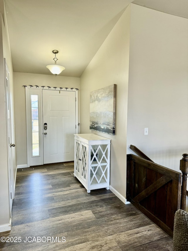 entryway with lofted ceiling, dark wood-style flooring, and baseboards