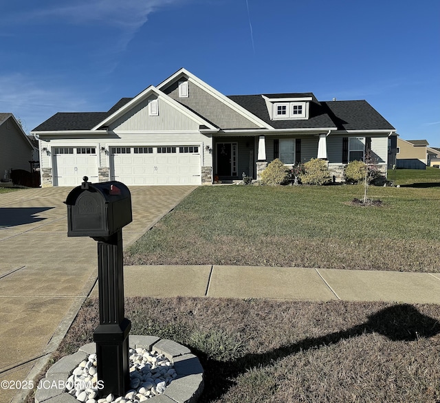 craftsman-style home featuring driveway, stone siding, an attached garage, and a front yard