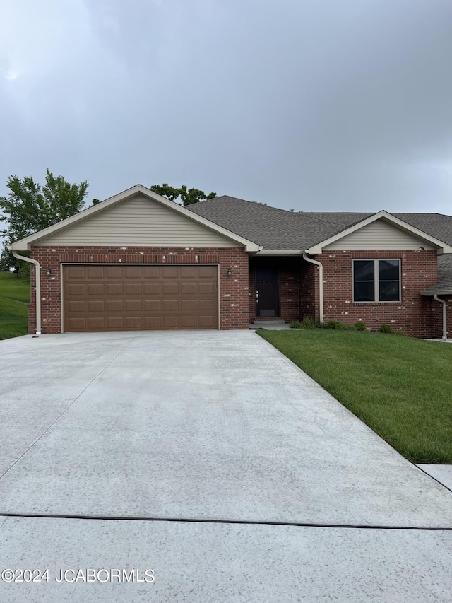 ranch-style house with a garage and a front lawn