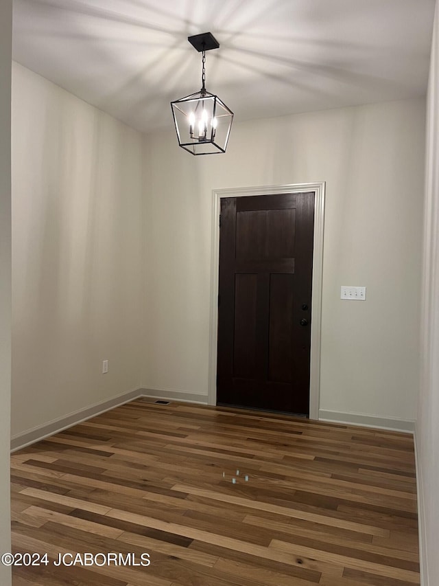 entrance foyer featuring dark hardwood / wood-style floors and an inviting chandelier