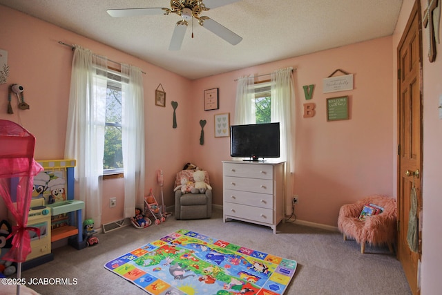 playroom with baseboards, ceiling fan, and carpet