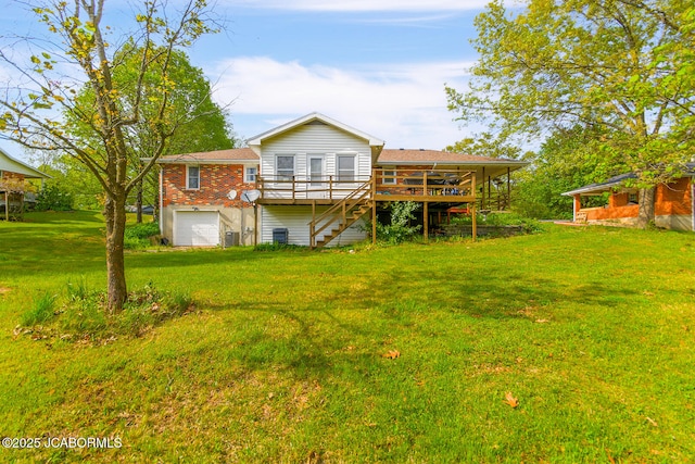 rear view of house with a lawn, an attached garage, a wooden deck, and stairs