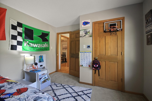 bedroom with baseboards and light carpet