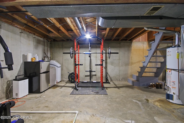 unfinished below grade area with water heater, freestanding refrigerator, stairs, washer / dryer, and visible vents