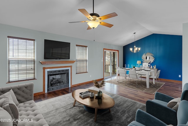 living room featuring ceiling fan with notable chandelier, lofted ceiling, and dark wood-type flooring