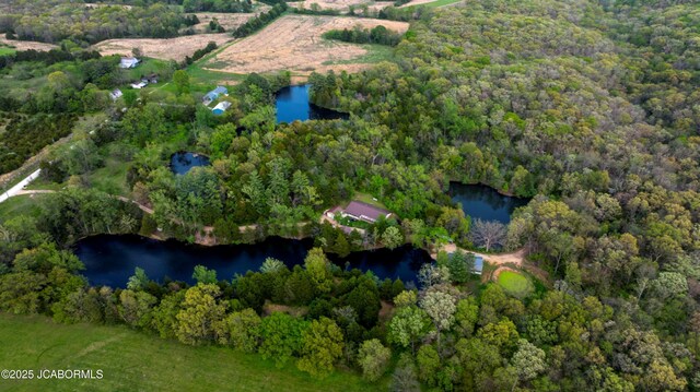 drone / aerial view with a water view and a wooded view