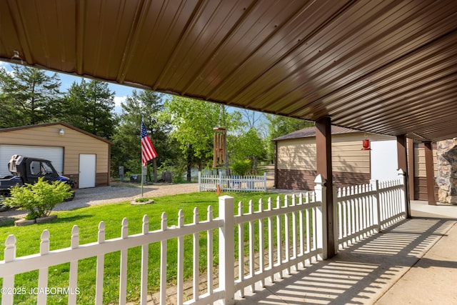 view of patio featuring a detached garage, fence, and an outdoor structure