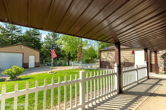view of patio / terrace featuring a detached garage, fence, and an outdoor structure