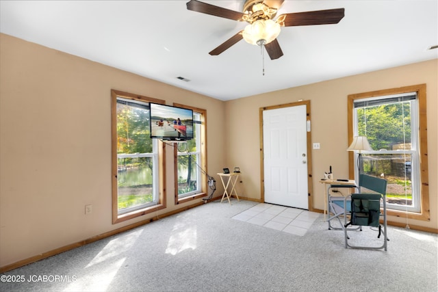 foyer entrance with baseboards, carpet flooring, a ceiling fan, and visible vents