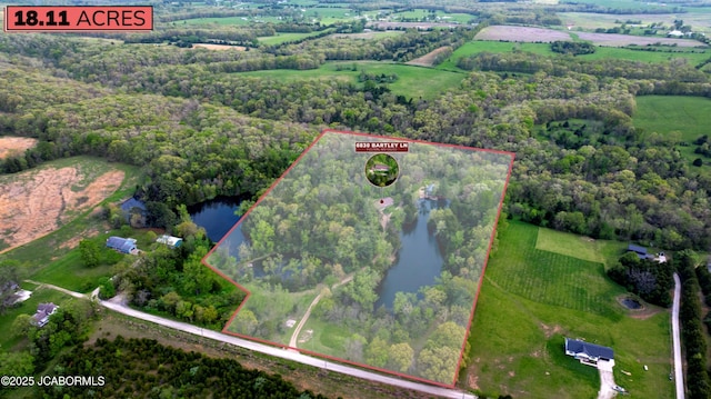 drone / aerial view featuring a water view, a rural view, and a wooded view