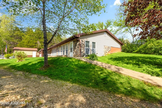 view of property exterior with a yard and stone siding