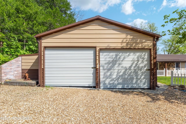 detached garage featuring fence