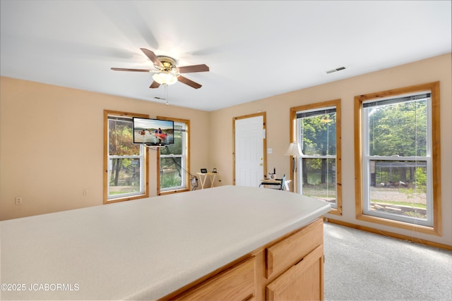 kitchen with light countertops, a ceiling fan, visible vents, and light carpet