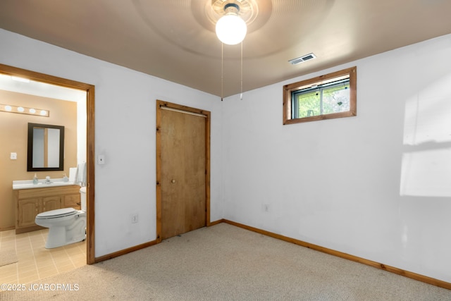 unfurnished bedroom featuring visible vents, baseboards, a closet, and light colored carpet
