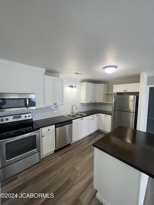 kitchen featuring white cabinets, sink, appliances with stainless steel finishes, and dark wood-type flooring