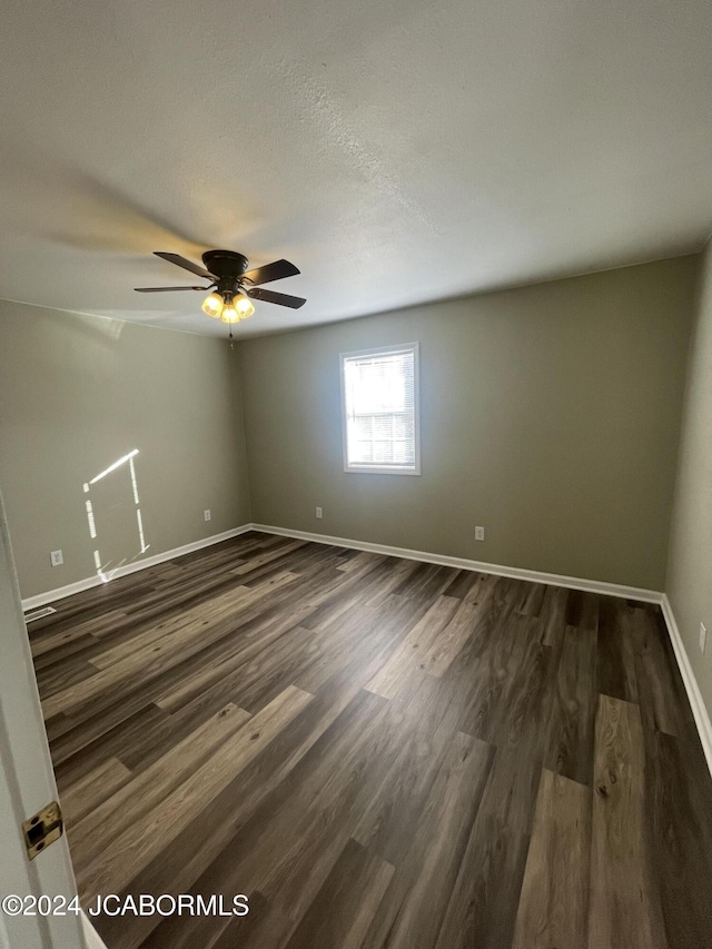 empty room featuring ceiling fan and dark hardwood / wood-style flooring