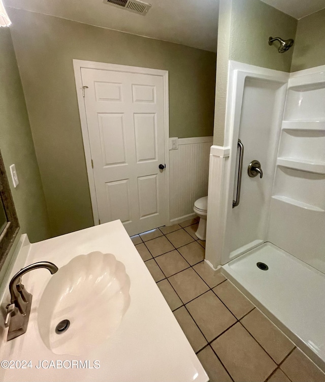 bathroom with a shower, tile patterned flooring, vanity, and toilet