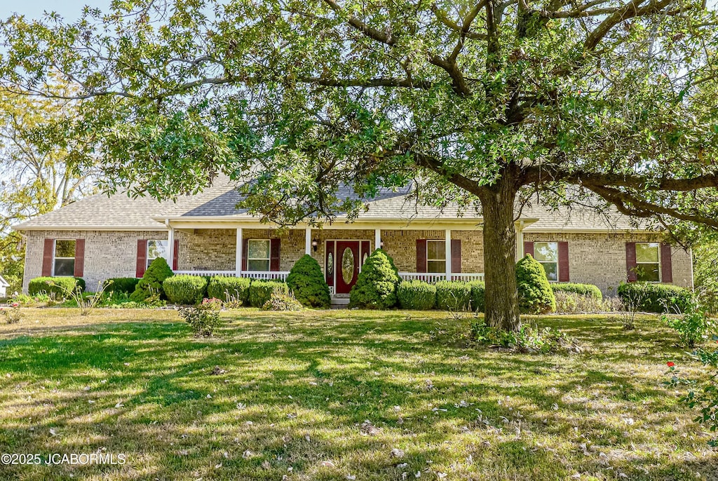 ranch-style house with covered porch and a front lawn