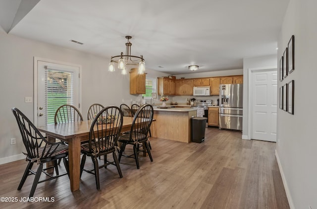 5112 Melissa Dr, Columbia, MO 65202 - dining room featuring healthy amount of natural light, light wood-style flooring, and a chandelier