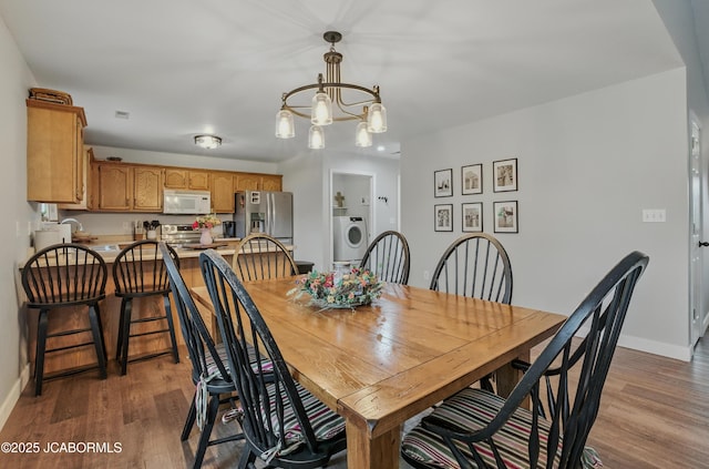 5112 Melissa Dr, Columbia, MO 65202 - dining room with washer / dryer, wood finished floors, and a chandelier