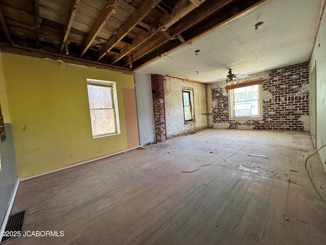 204 Havana St, Jefferson City, MO 65109 - unfurnished living room featuring ceiling fan, hardwood / wood-style flooring, and brick wall