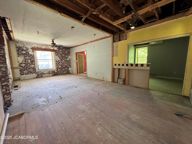 204 Havana St, Jefferson City, MO 65109 - unfurnished living room with a ceiling fan, wood-type flooring, and brick wall