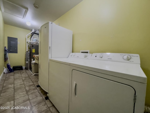 clothes washing area featuring baseboards, attic access, electric panel, laundry area, and separate washer and dryer