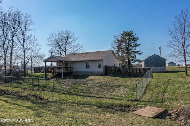 rear view of house featuring a wooden deck, a lawn, and a fenced backyard