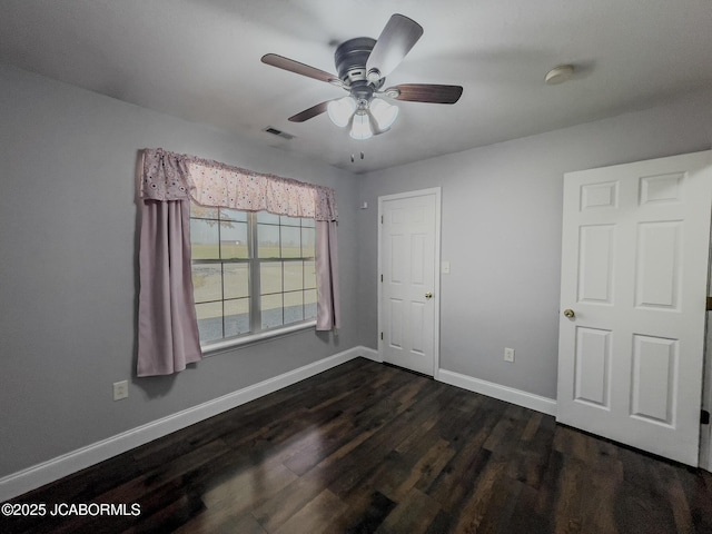 unfurnished bedroom featuring visible vents, a ceiling fan, baseboards, and dark wood-style flooring