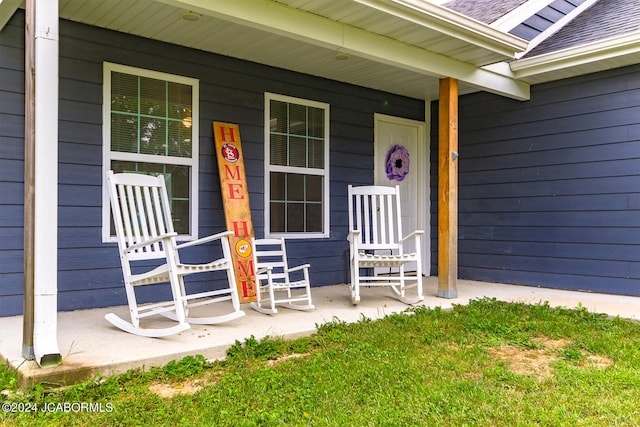 view of exterior entry featuring a porch and roof with shingles