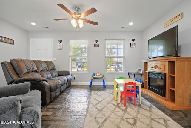 living room with recessed lighting, baseboards, wood finished floors, and a glass covered fireplace