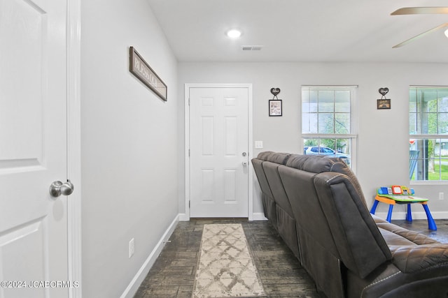 interior space featuring dark wood-style floors, visible vents, ceiling fan, and baseboards